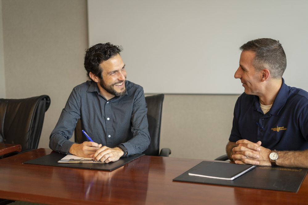 2 staff working at a table and smiling