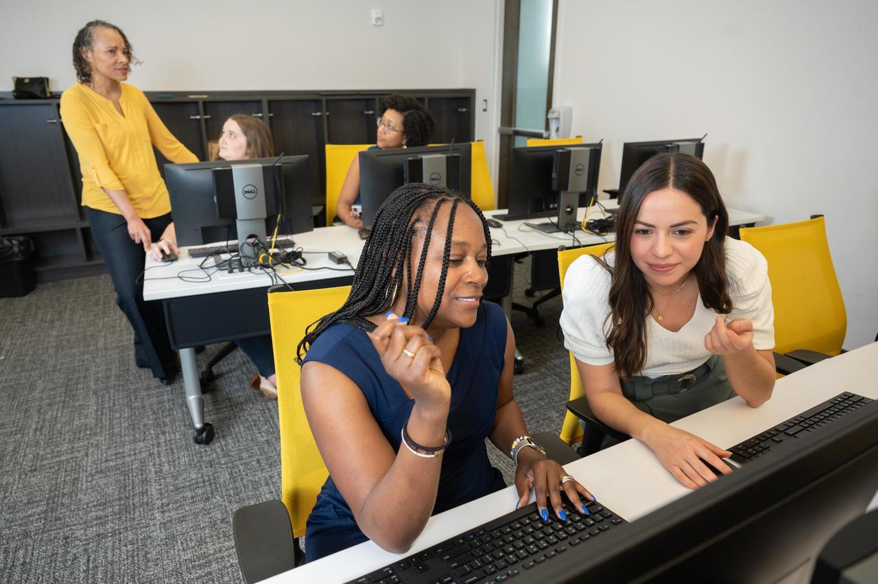 Staff members collaborating around a computer