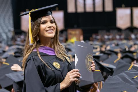 Georgia Tech graduate stands in crowd at commencement.