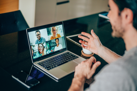 Person at laptop engaging with others on a virtual conference call.