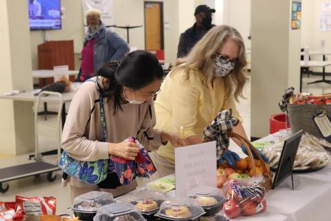two ladies in front of a snack table