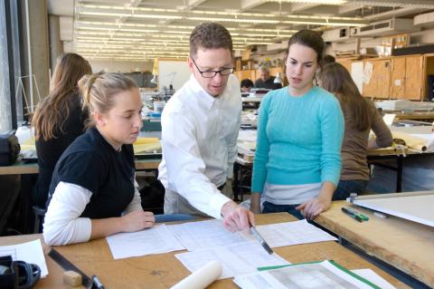 Professors and teaching assistants are pictured with students in classroom settings